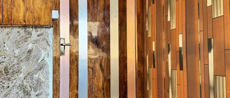 Un interior moderno con una puerta de madera que indica '201', un papel tapiz estampado y un piso de madera.