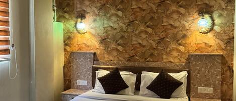 A hotel room with a marble bed, a stone-patterned wall, and two wall-mounted lights.