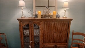 A wooden cabinet with glass doors and a candle holder on top.