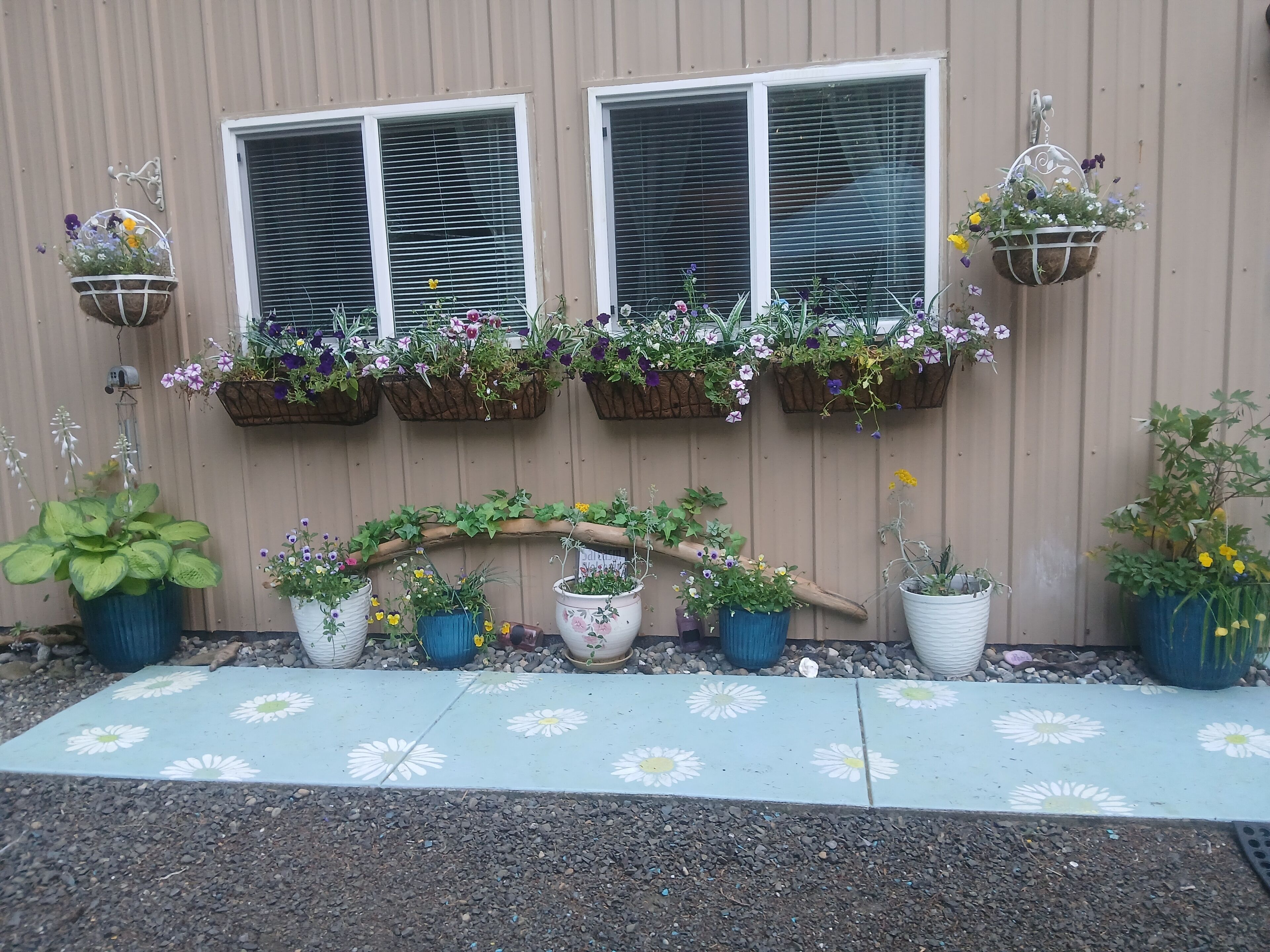 A building facade with multiple flower planters and a decorative wooden archway.