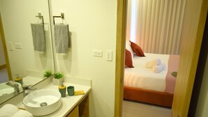 A bathroom with a sink, mirror, and towel rack.