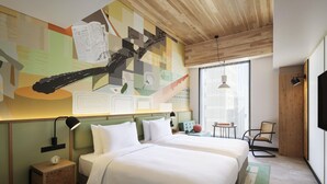 Ett hotellrum med två sängar, ett träpanelat tak, ett stort fönster, en tv och en vägg med abstrakt konst.