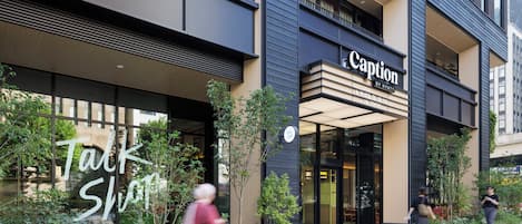 Un edificio moderno con un cartel que dice 'Caption by Hyatt' y un cartel que dice 'Talk Shop'.