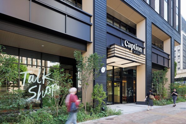 Un edificio moderno con un cartel que dice 'Caption by Hyatt' y un cartel que dice 'Talk Shop'.