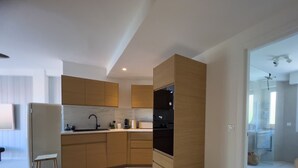 A modern kitchen with wooden cabinets, a black oven, and a built-in microwave. - LE ROSSINI Antibes Center, AirCo, Parking for 4 By Sunset (Antibes)
