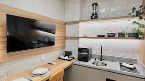A modern kitchen with a built-in TV, a coffee machine, a blender, and a microwave. - AD 330 (São Paulo)