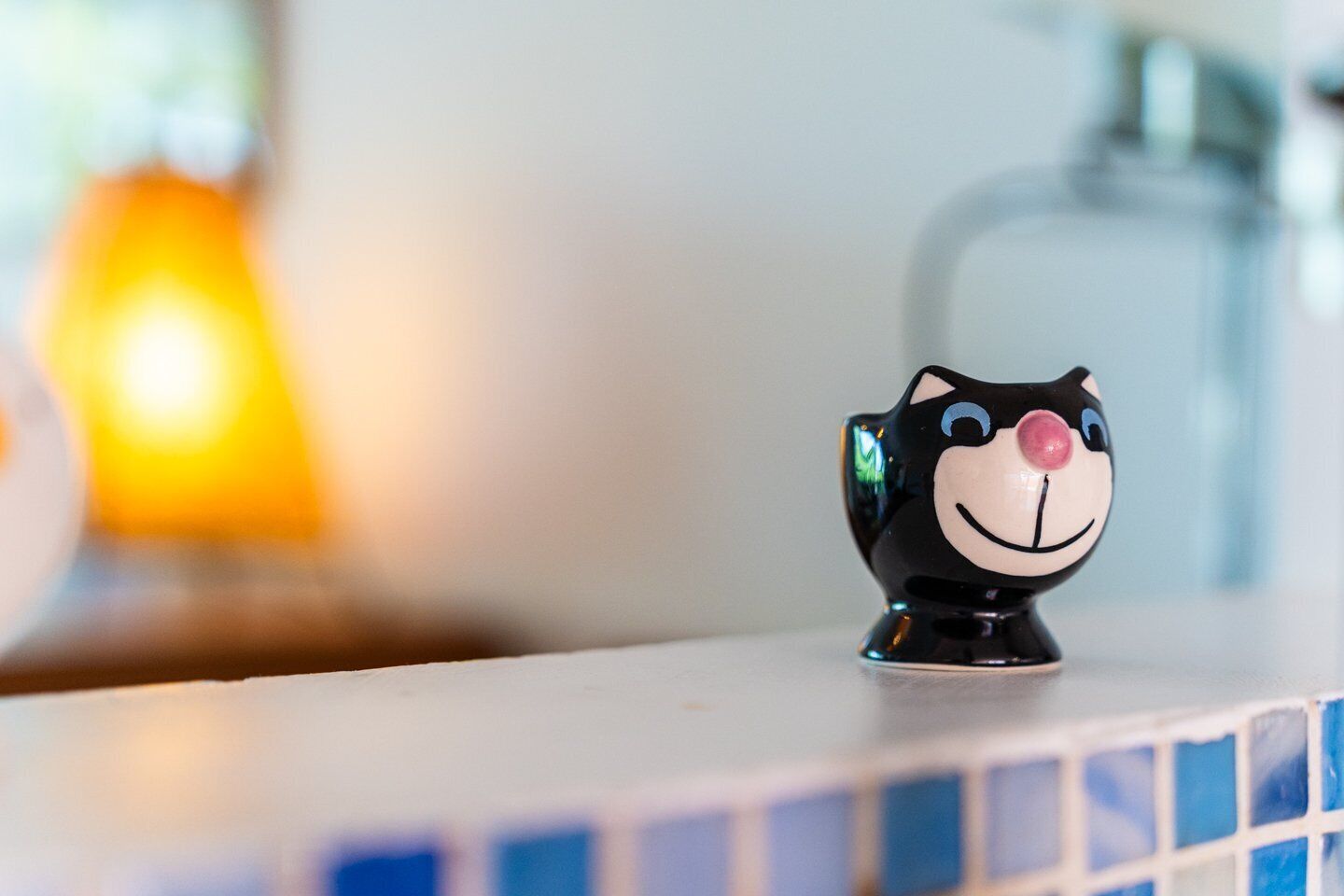 A black cat-shaped salt and pepper shaker on a tiled countertop.