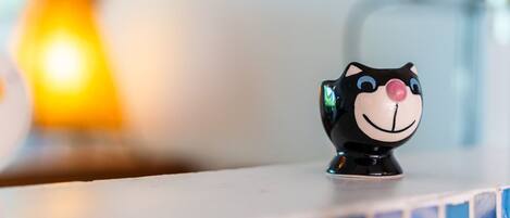 A black cat-shaped salt and pepper shaker on a tiled countertop.