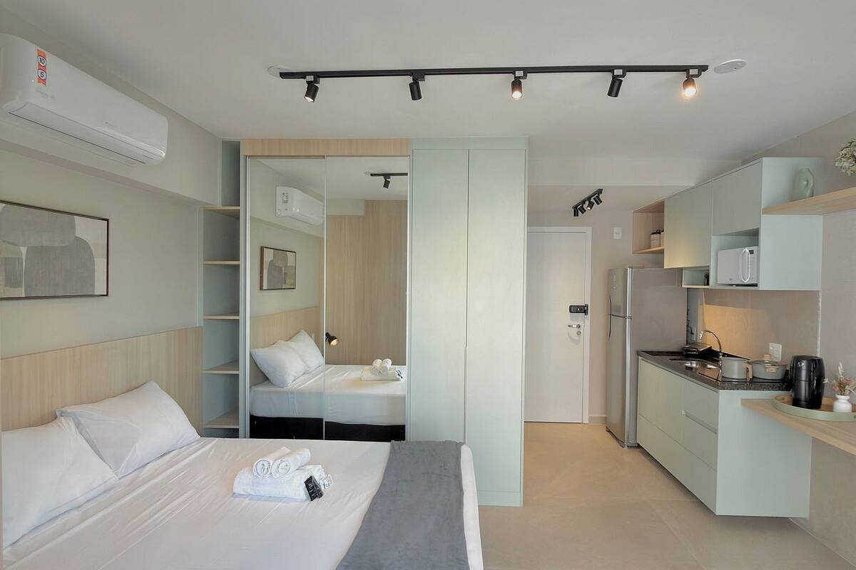 Une chambre d’hôtel moderne équipée d’un lit, d’une table de chevet et d’une kitchenette.