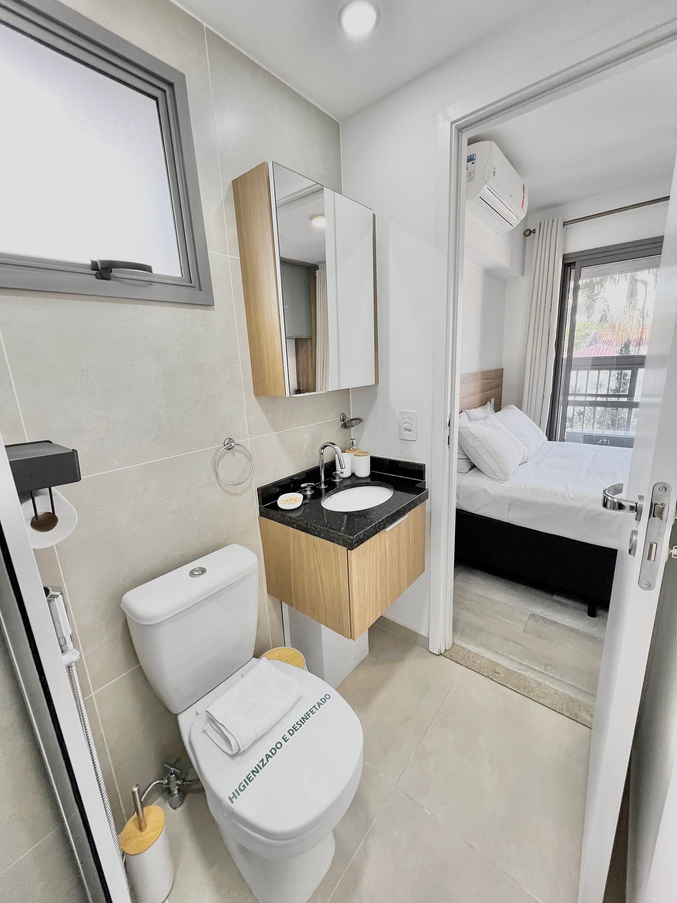 A modern bathroom with a toilet, sink, and mirror.