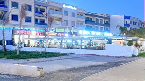 Une zone commerciale comprenant une rangée de boutiques et un restaurant.