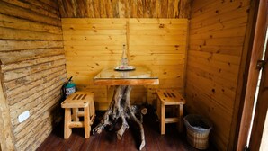 A wooden cabin with a glass-top table, two stools, and a wooden floor. - Hostal La Laguna (Villamaria)
