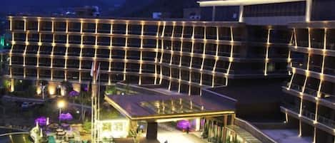 Un hotel de diseño moderno, con un patio central que cuenta con una fuente y rodeado de abundante vegetación.