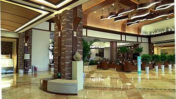 A spacious lobby with a high ceiling, large columns, and a central seating area.