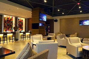 A hotel lobby with seating, a bar area, and a television screen. - Tiantai Yunjie International Hotel (Xiuwu)