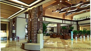 A spacious lobby with a polished marble floor, a central seating area, and a modern ceiling design. - Tiantai Yunjie International Hotel (Xiuwu)