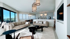 Un salon moderne doté d’une grande fenêtre, de deux canapés, d’une table basse et d’un coin repas.