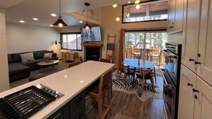 Une cuisine moderne dotée d’un îlot central, d’un coin repas et d’un espace salon confortable.
