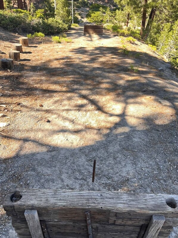 Un sendero de grava con postes y bancos de madera en un área boscosa.