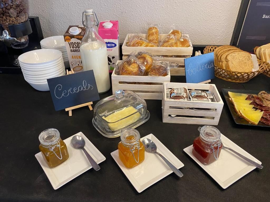 Un bufé de desayuno con diversas opciones de comida, como cereales, pan y diferentes acompañamientos.