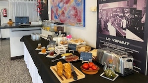 A buffet table with various food items and a poster of a vintage car.