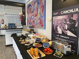 Una mesa de buffet con diversos alimentos y un cartel de un coche antiguo.