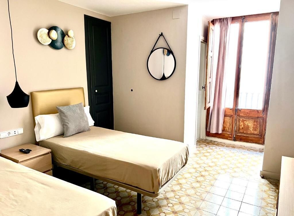 Une chambre d’hôtel avec un lit, une table de chevet et un miroir au mur.