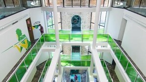 A multi-level atrium with glass railings and a central staircase.