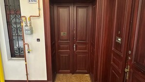 A wooden door with a "WELCOME" mat and a "PATIO" sign above it.