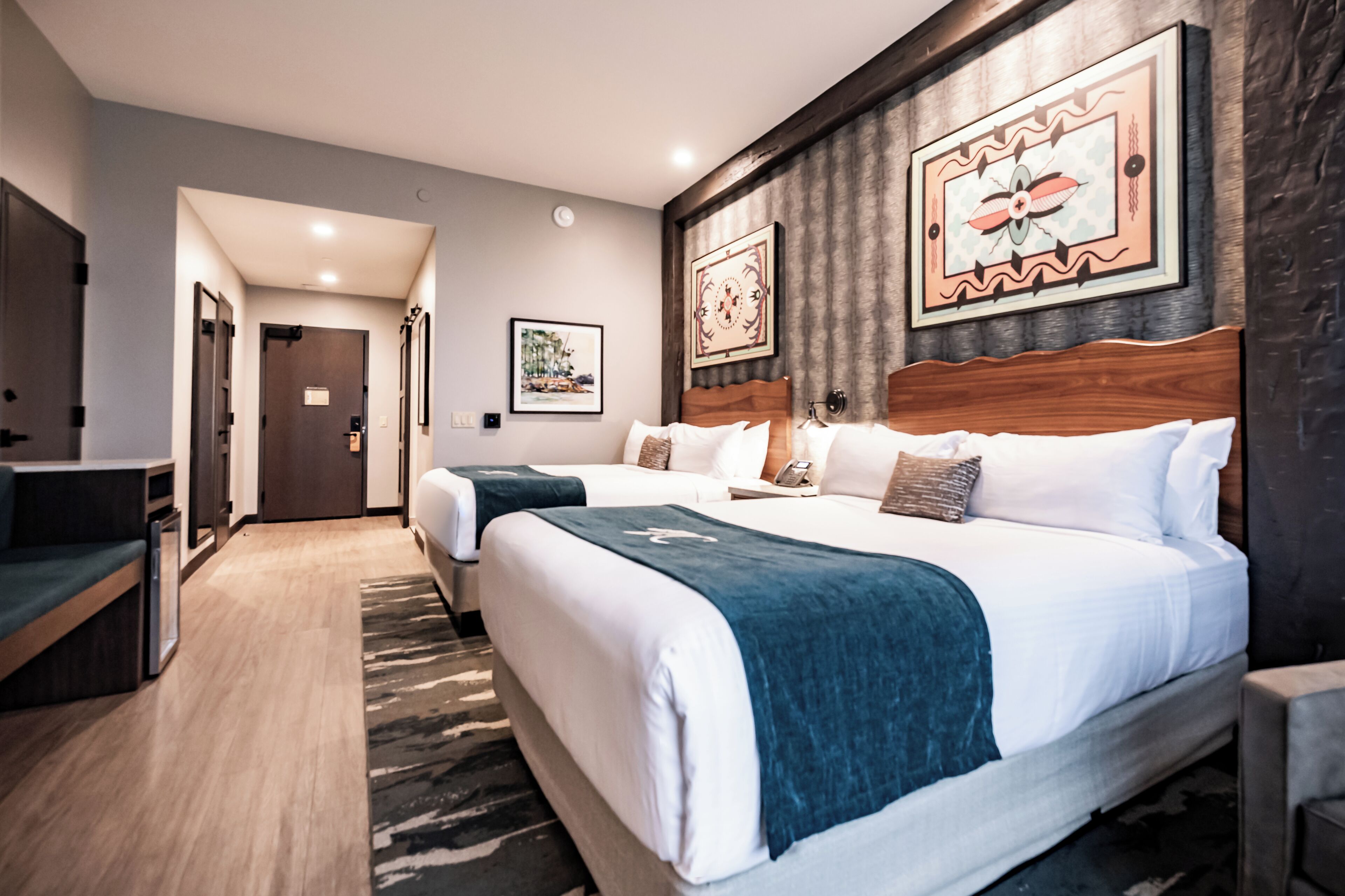 Ett hotellrum med två sängar, ett skrivbord och en garderob.