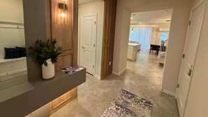 A modern interior with a reception desk, a potted plant, and a view into a dining area. - Family Friendly 5Bd Near Disney Windsor Cay 16136 (Clermont)