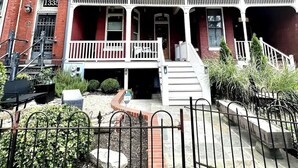 A red brick building with a white porch and a black metal fence. - LUXURIOUS DC ESTATE, BEST LOCATION BLOCK AWAY FROM 14TH/U ST NW W/ 2 CAR PARKING (Washington)