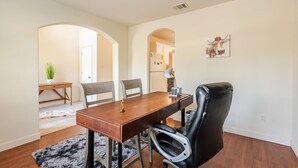 A dining area with a wooden table, black leather chairs, and a black and white rug. - Spacious 4-bedroom house in fantastic Buda with WiFi, game /fitness room& more! (Buda)