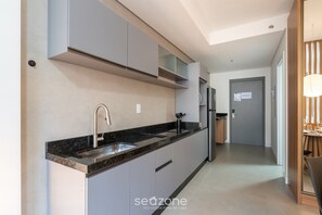 Una cocina moderna con pileta integrada, electrodomésticos de acero inoxidable y un comedor con mesa y sillas.