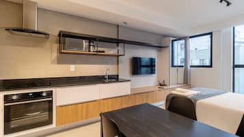 Una cocina moderna con electrodomésticos integrados, un comedor y un amplio ventanal con vistas a la ciudad.