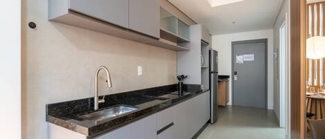 A modern kitchen with a built-in sink, stainless steel appliances, and a dining area with a table and chairs.