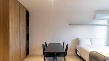 A modern room with a dining table, chairs, a sofa, and a wardrobe.