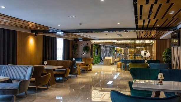 A modern hotel lobby with seating areas, a reception desk, and a bar/lounge area. - M-one Hotel (Guiyang)