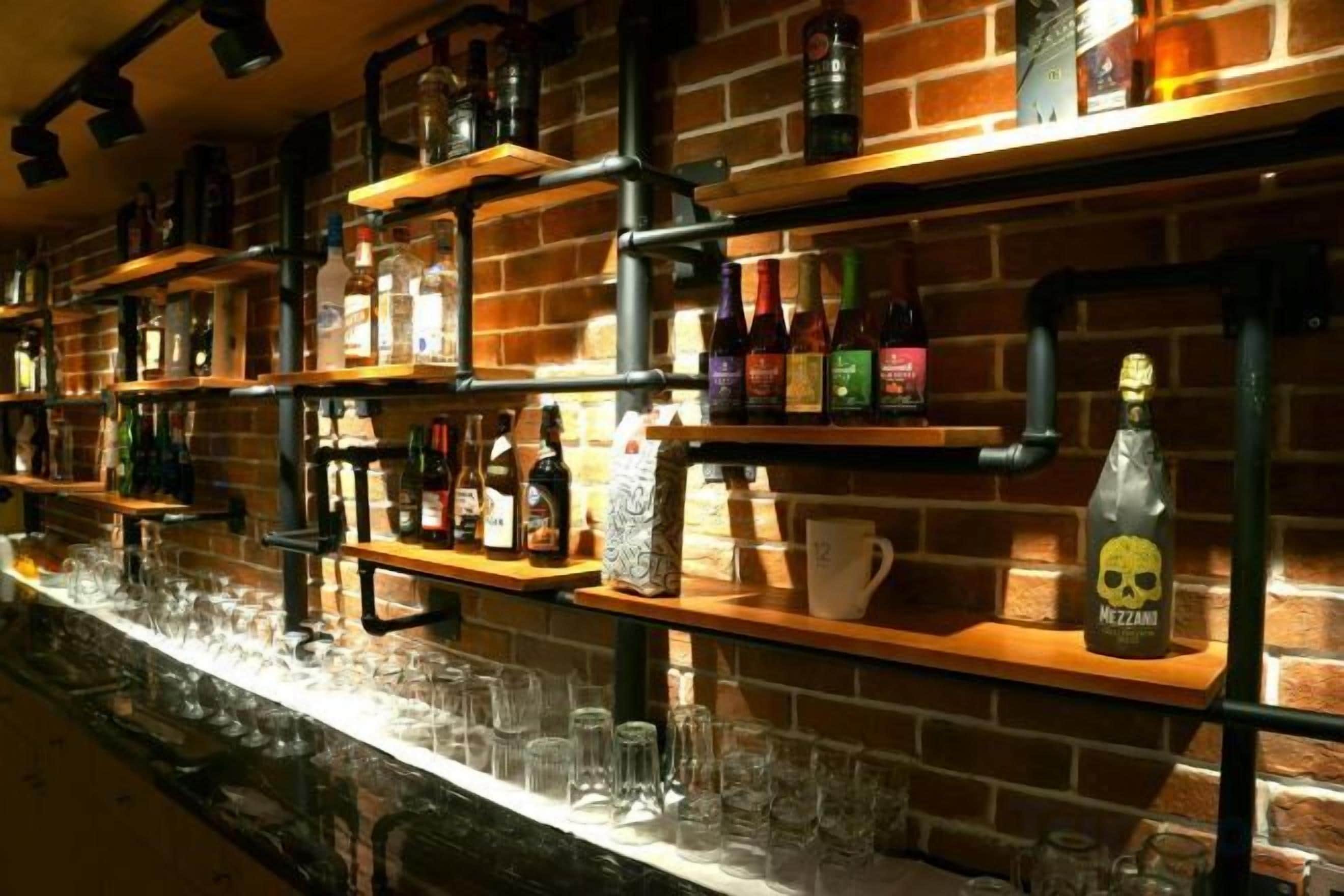 A bar area with shelves stocked with bottles and glasses.