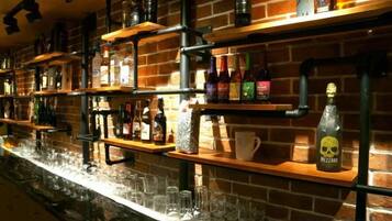 A bar area with shelves stocked with bottles and glasses.