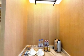 A small kitchenette area with a microwave, kettle, and various food and drink items. - M-one Hotel (Guiyang)