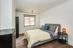 Spacious double bedroom with plenty of storage, including a chest of drawers, wardrobe, and extra cupboard for luggage. Blackout blinds ensure a restful night’s sleep