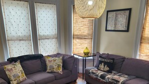 A living room with two sofas, a coffee table, and a small side table. - Coastal Charm  – Walk to Beach or Train! (Swampscott)