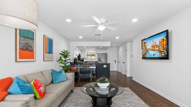 A modern living room with a sofa, coffee table, and artwork on the walls.