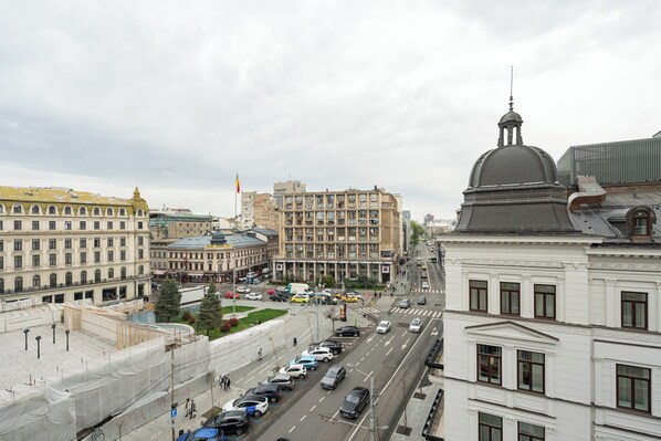 Un paysage urbain avec un imposant bâtiment blanc surmonté d’un dôme et un grand bâtiment jaune également surmonté d’un dôme.