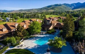 Una zona residencial con casas, una piscina y montañas al fondo.