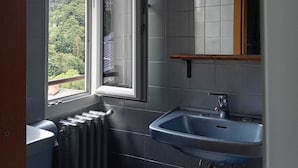 A bathroom with a window, a sink, and a radiator. - L'Ostu Di San Giacu (Boves)