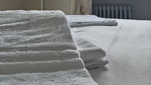A hotel room with a bed, a window with a view of a tower, and a towel rack. - L'Ostu Di San Giacu (Boves)