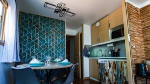 A compact kitchen with a dining area, featuring a geometric backsplash, wooden cabinets, and a rustic wall. - Luxury apartment, swimming pool, tennis, beach (Cannes)