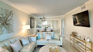 Un salon moderne avec un canapé, une table basse et un téléviseur fixé au mur.